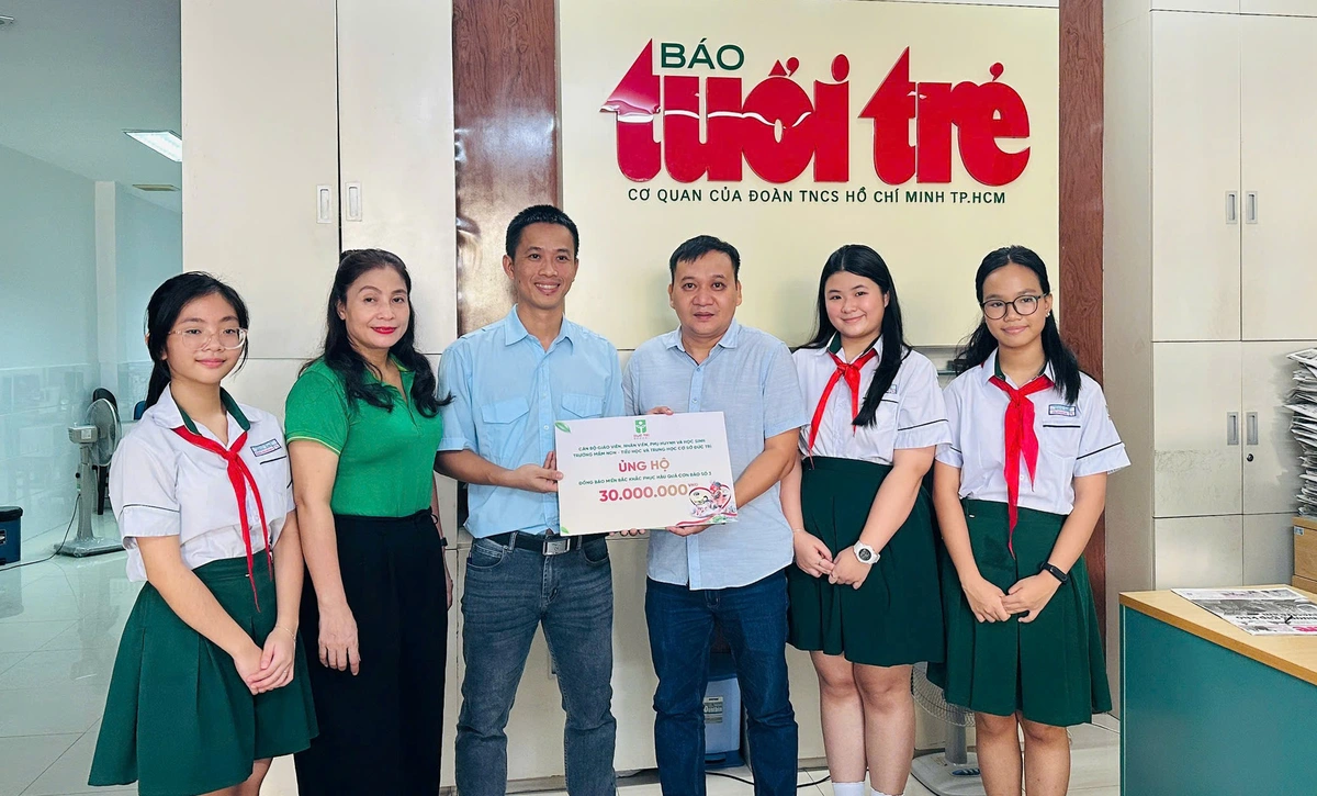 Giáo viên, học sinh Trường mầm non - tiểu học và trung học cơ sở Đức Trí trao số tiền ủng hộ đồng bào bão lũ tại toà soạn báo Tuổi trẻ